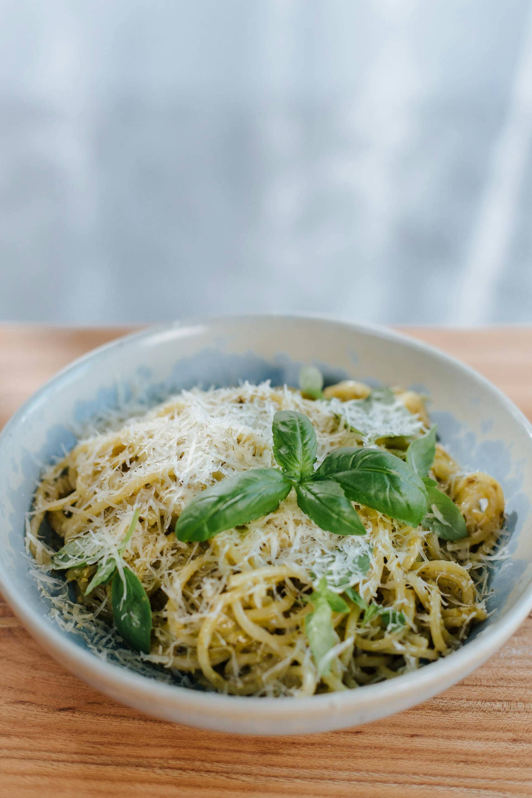 A tempting bowl of pasta with fresh basil and parmesan, perfect for Italian cuisine lovers.