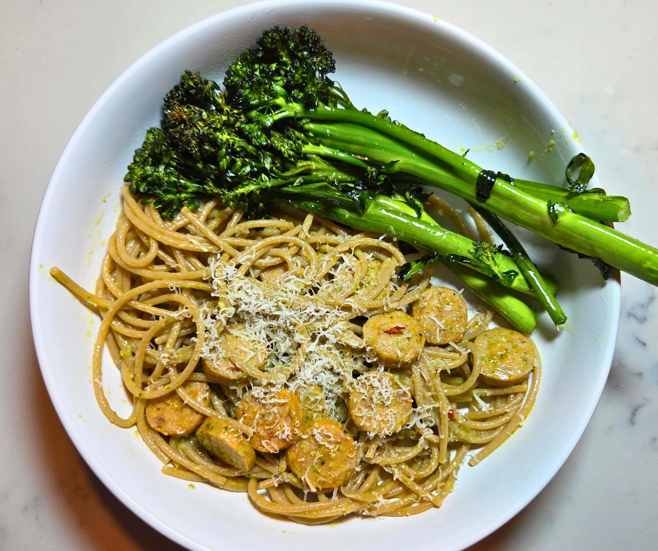 bowl of pasta with sausage and pesto with broccolini