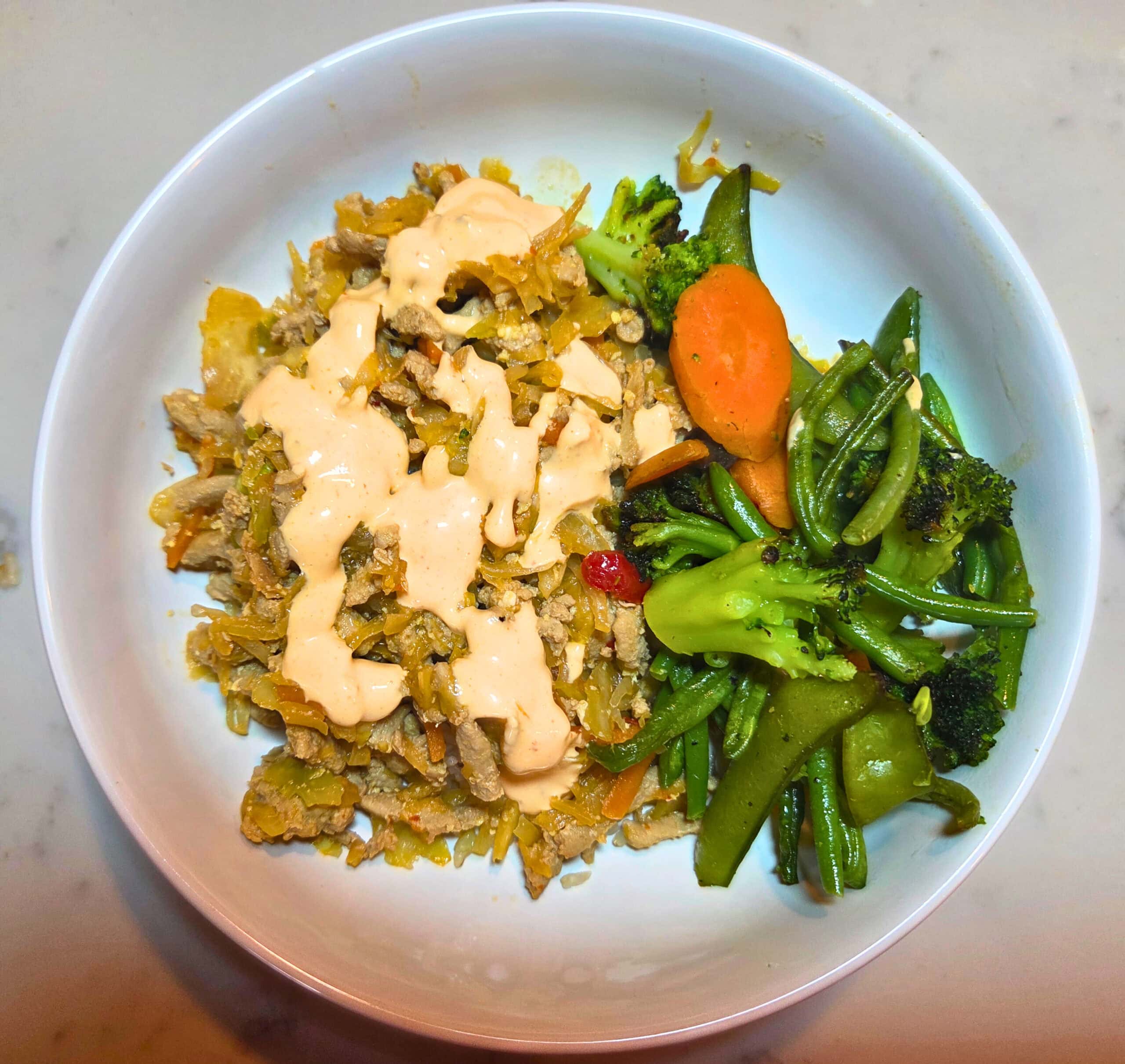 egg roll in a bowl with a side of stir fry vegetables