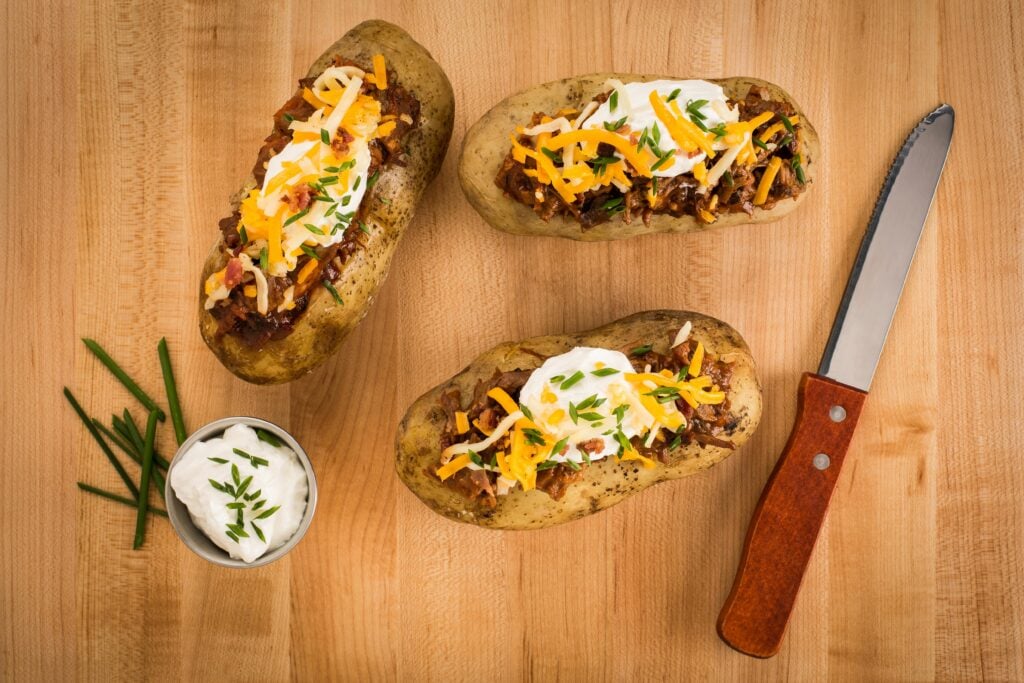 baked potatoes topped with chili, cheese and sour cream