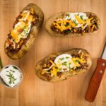 baked potatoes topped with chili, cheese and sour cream